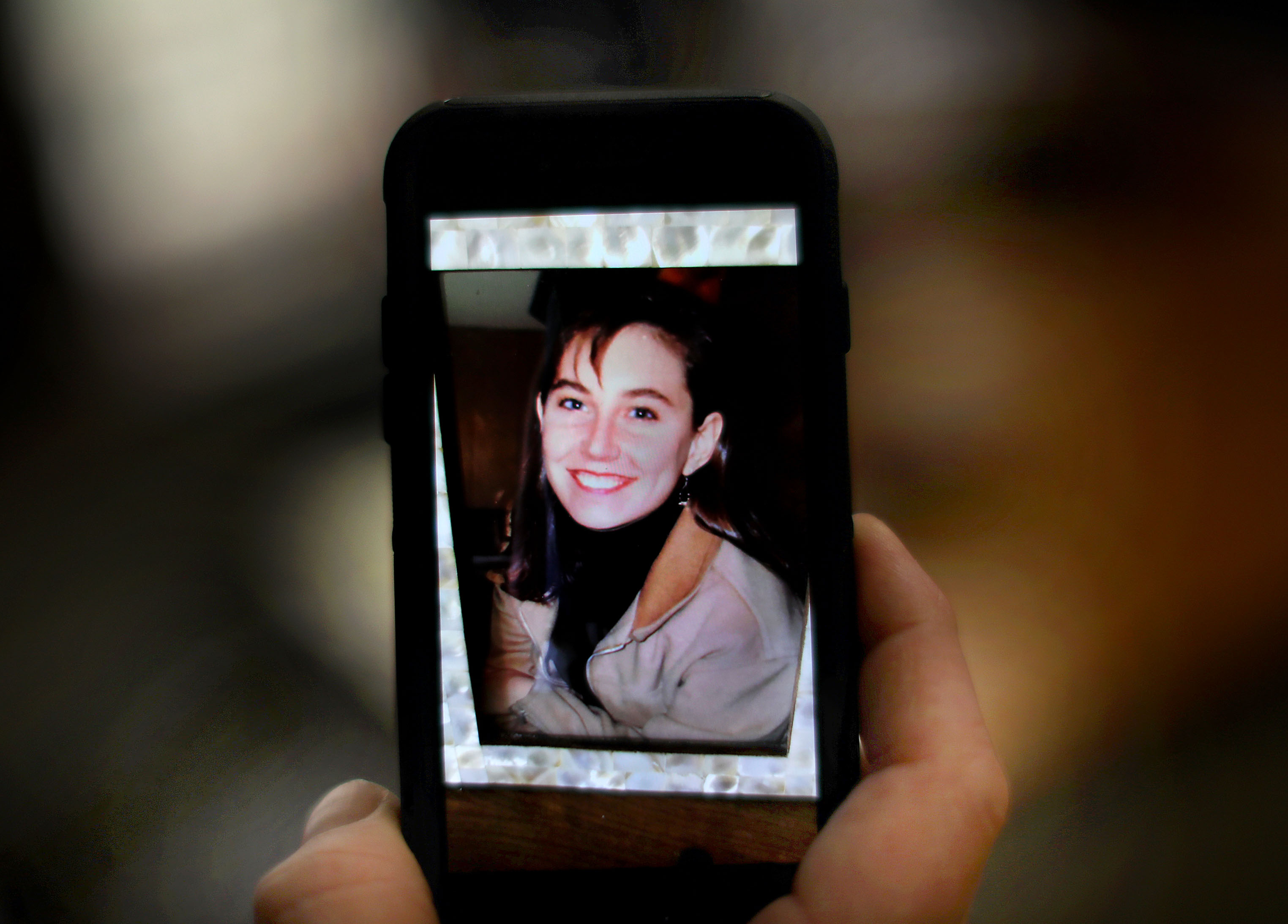 Liam Lowney held a photograph he keeps on his cellphone of his sister, Shannon Lowney.