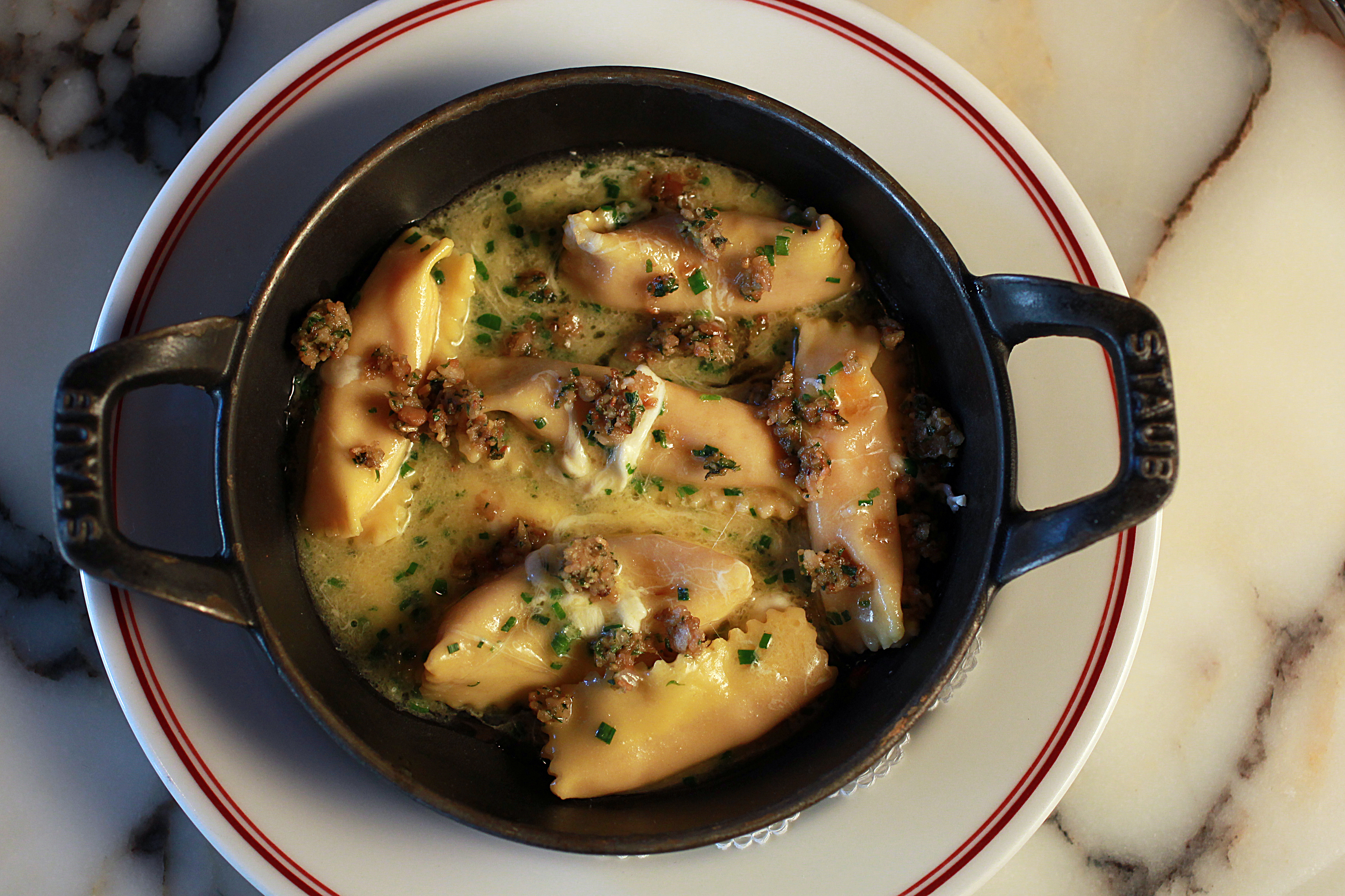 Carrot agnolotti sprinkled with pine nuts.