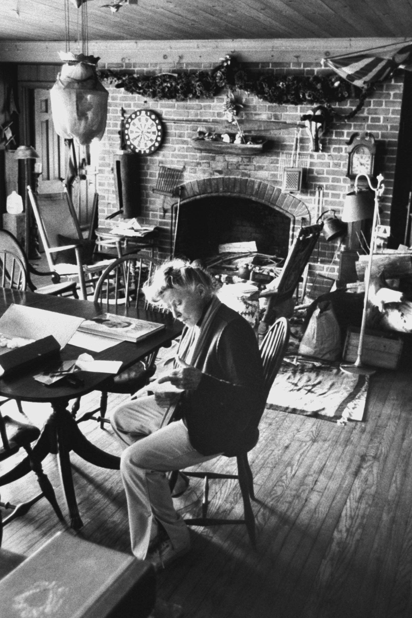 Katharine Hepburn reads a letter in the home, filled with New England antiques, in 1990.
