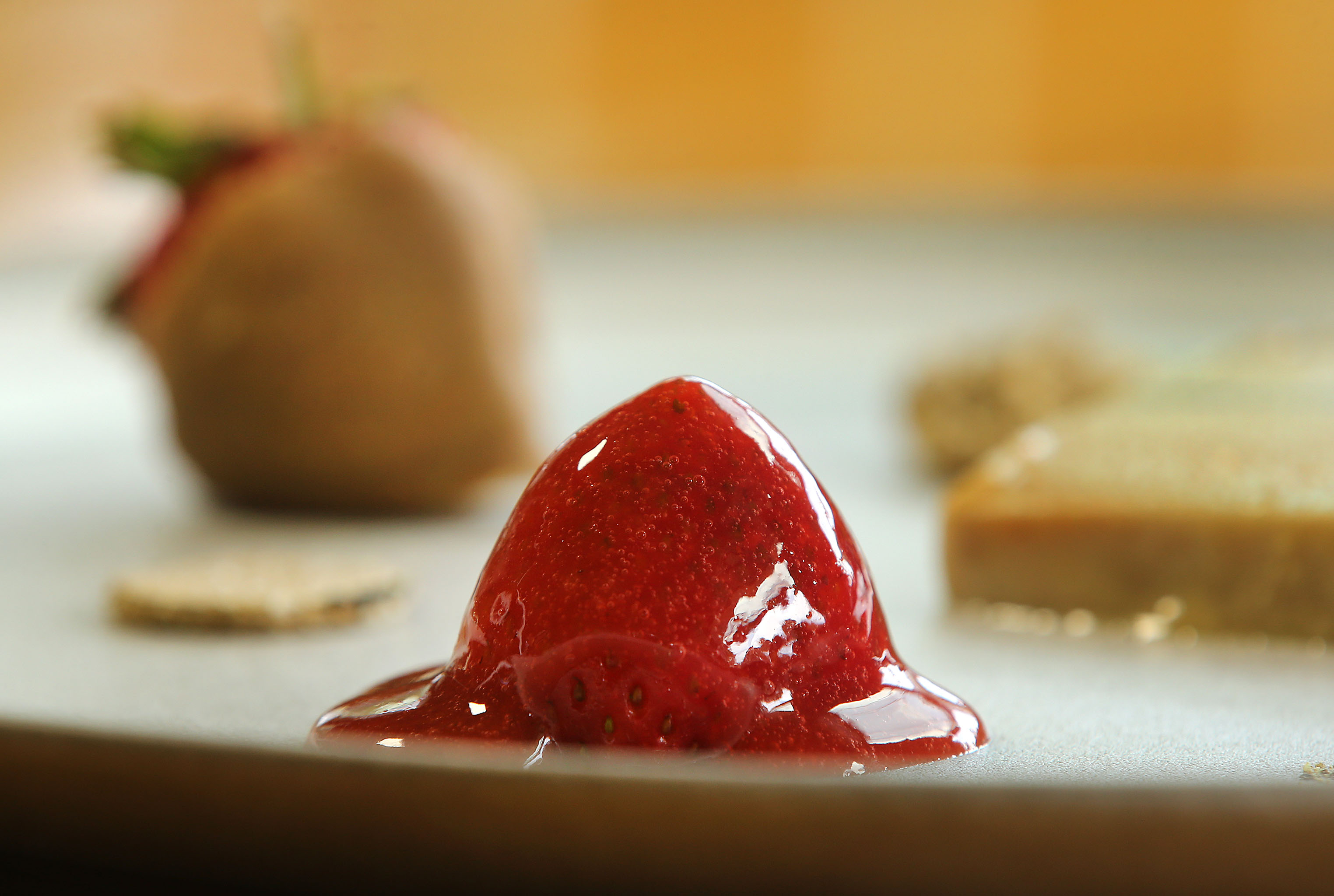 A strawberry adorns a foie gras dish.