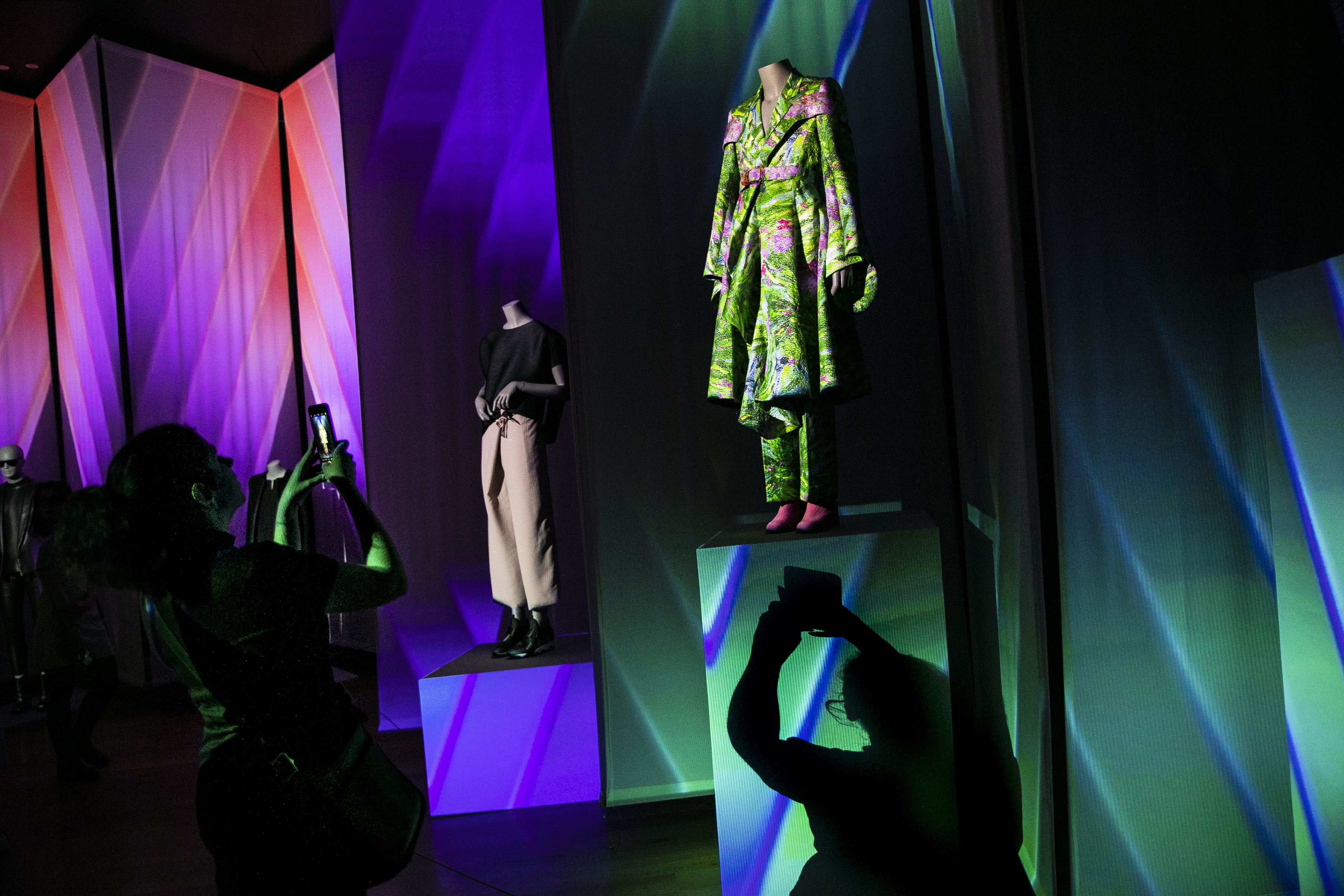 A museum-goer photographed outfits on display at the Gender Bending Fashion exhibit at the MFA during the opening preview night.