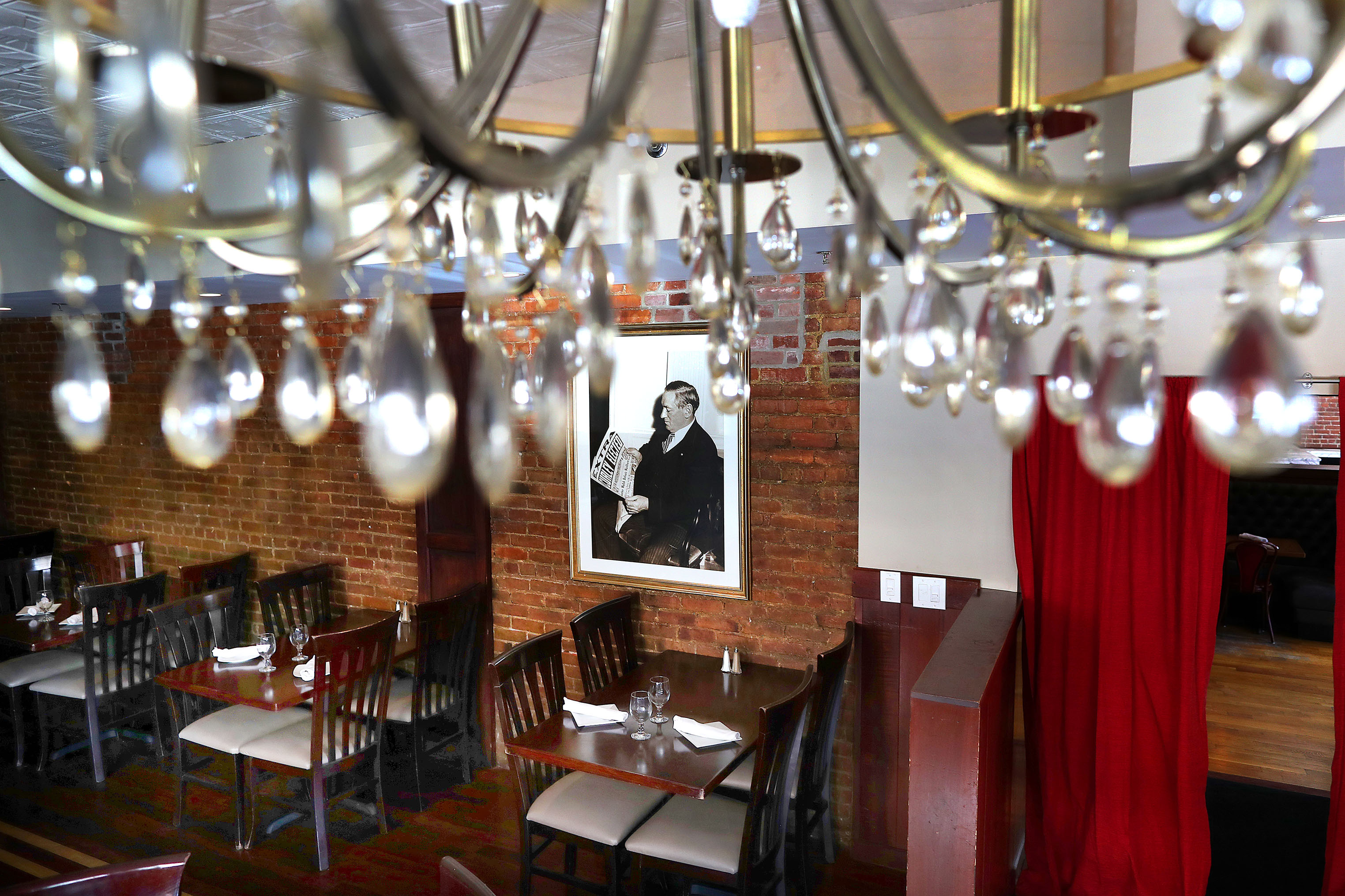 An ornate chandelier hung from the ceiling framing a photograph of James Michael Curley.