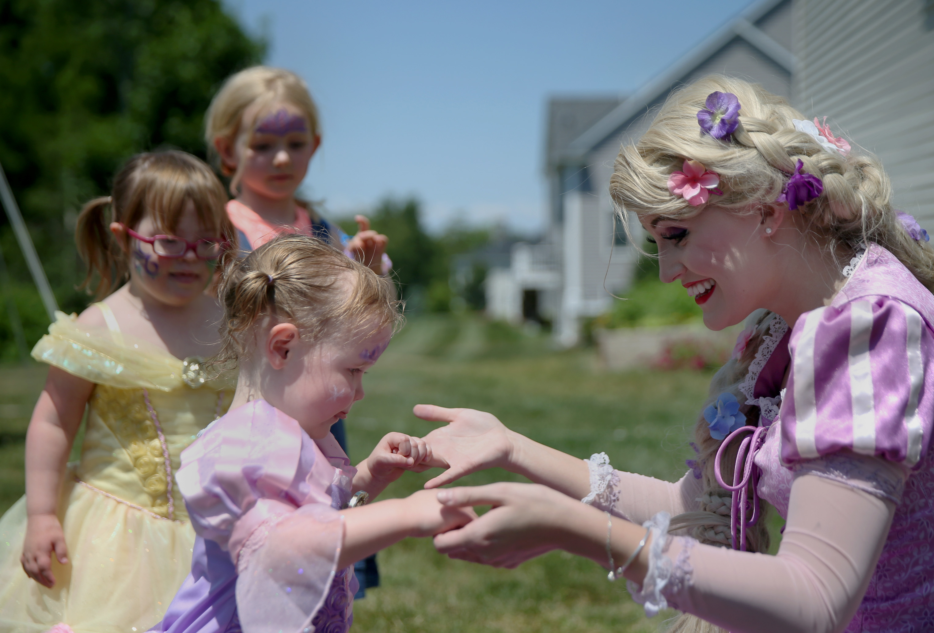 Busby holds hands with Emma Genest, 2, also dressed as Rapunzel.