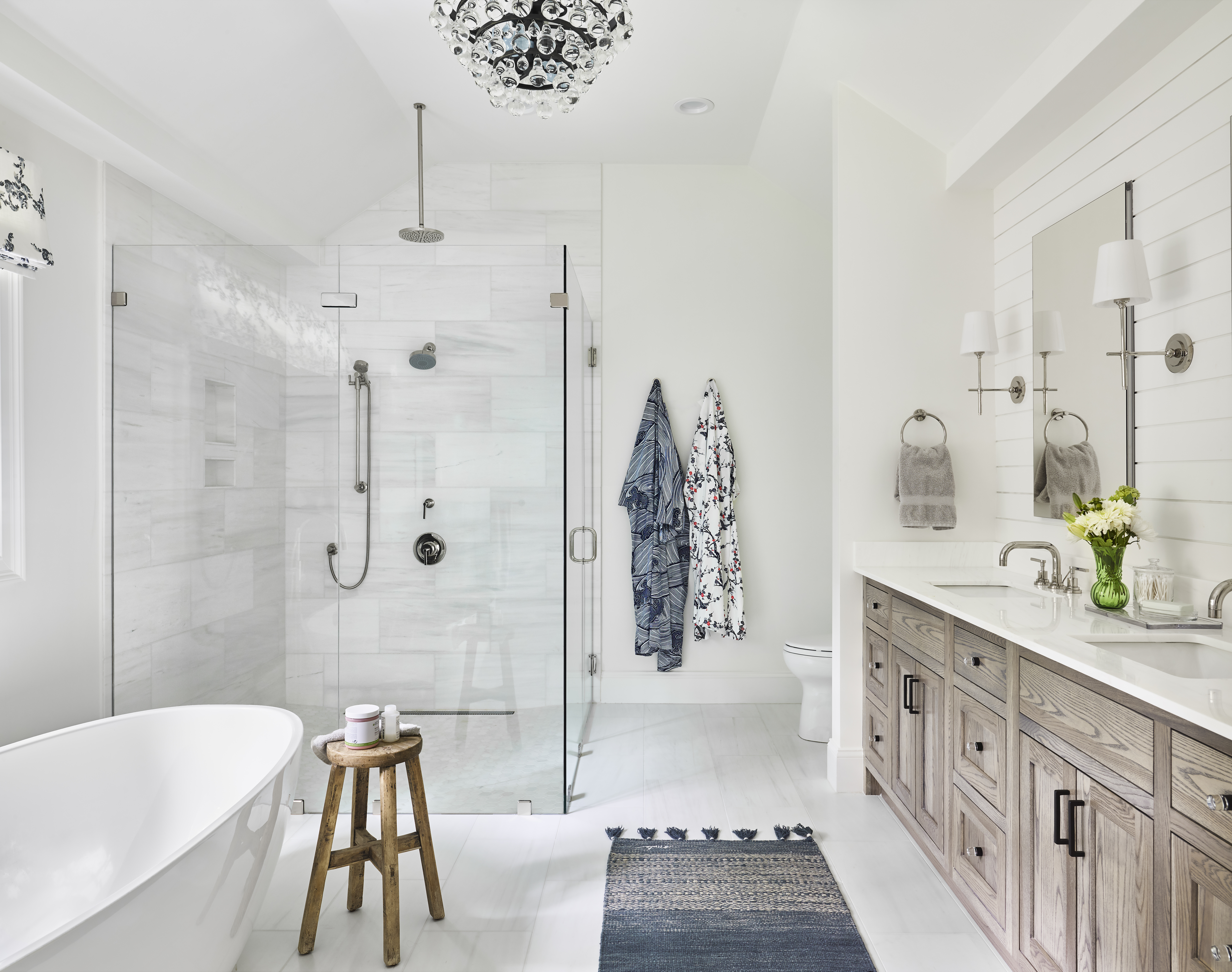 The chandelier, by Robert Abbey, lends glamour to the master bath.