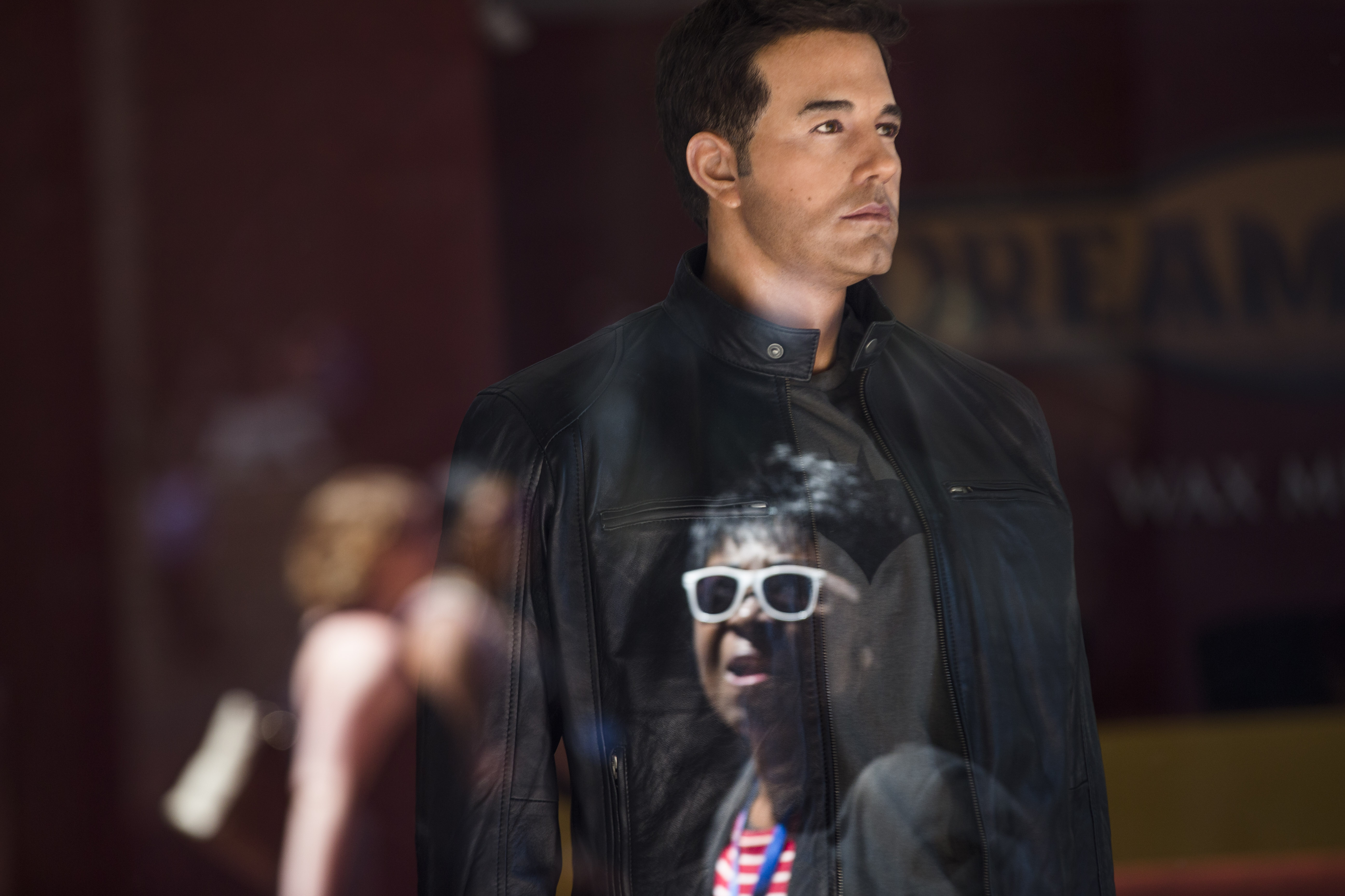 A passerby is reflected in a window as she looks at a wax figure of actor Ben Affleck at the Dreamland Wax Museum in Boston.