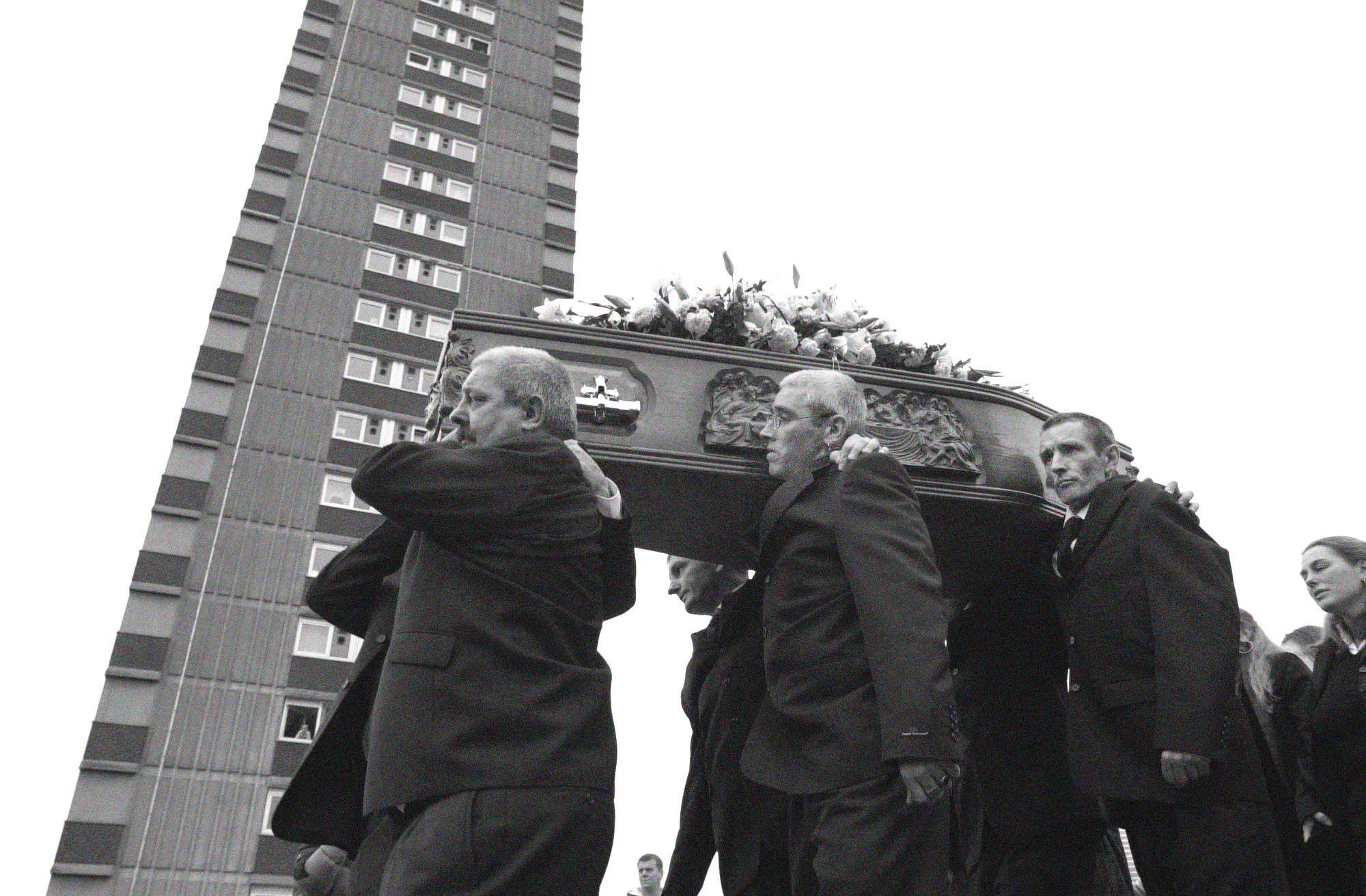 Pallbearers carry Jean McConville’s coffin past the Divis Towers.