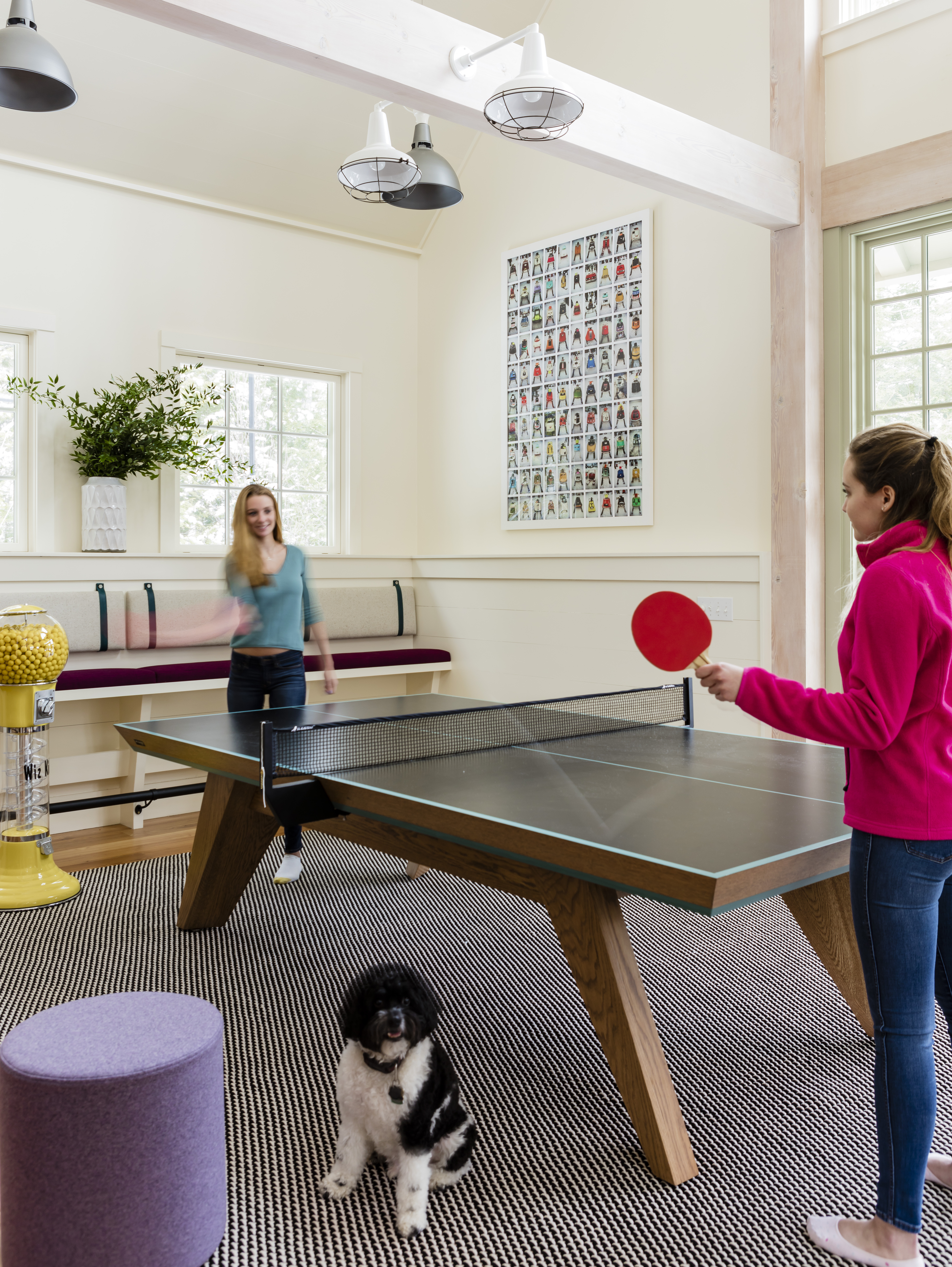 Lindsey and Katherine play Ping-Pong while the family cockapoo, Jack, poses for a photo.