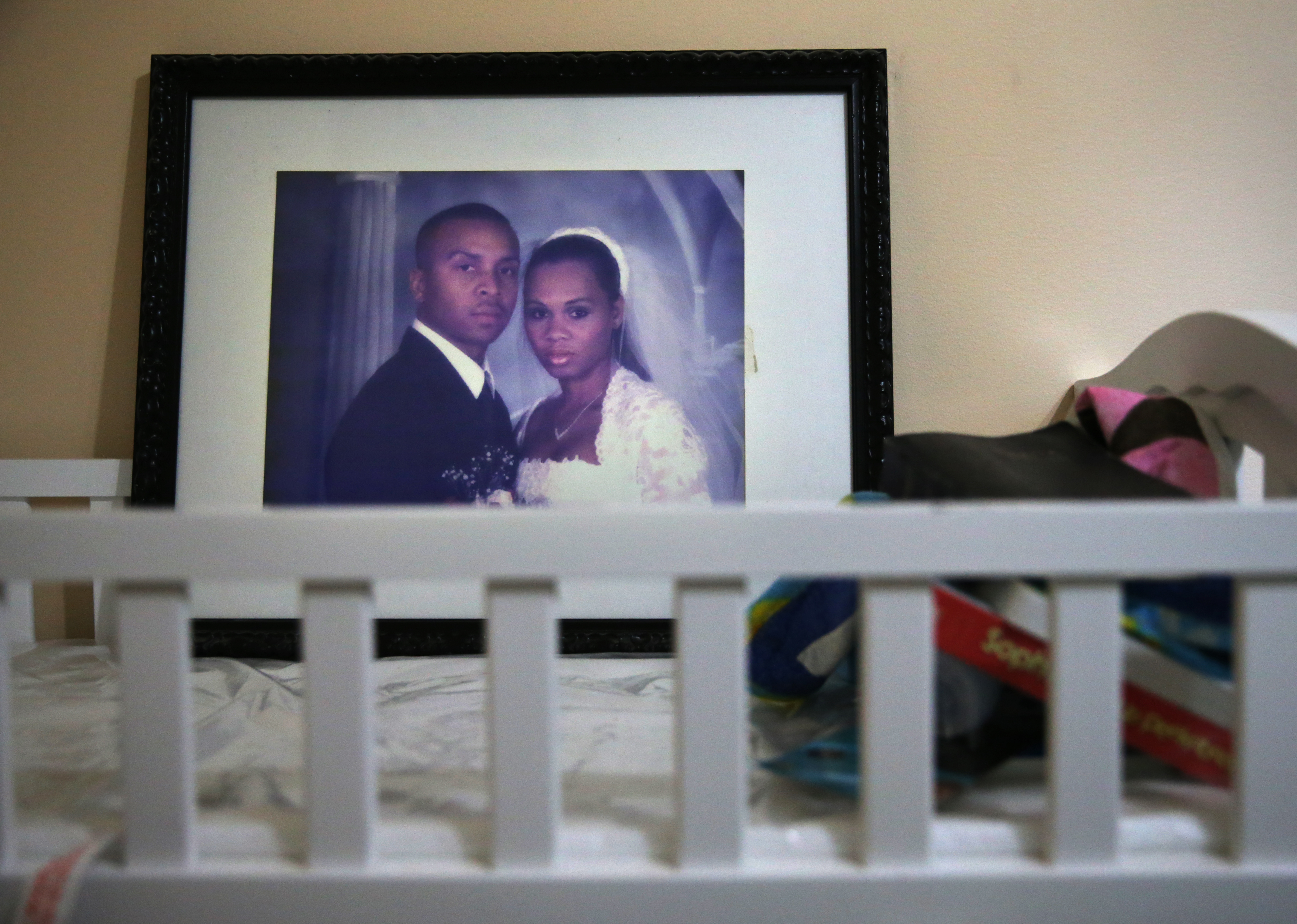 Kenny Fuchu keeps a wedding photograph of himself and his deceased wife, Seveny, on their son’s changing table at his home.