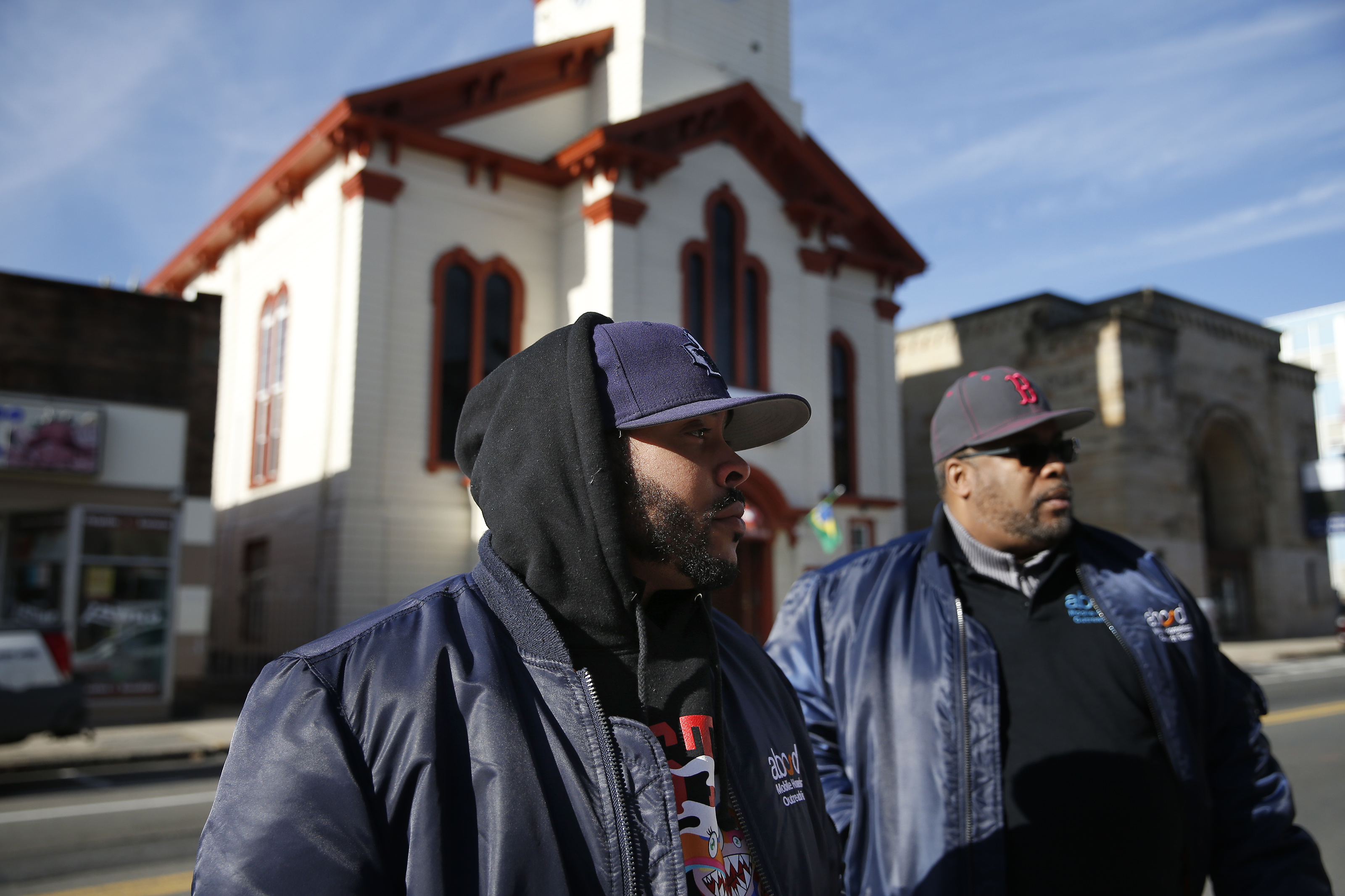 Aaron Blythe (left) and Richard Matos-Haile talk with a person in need of housing assistance on Broadway in Everett.