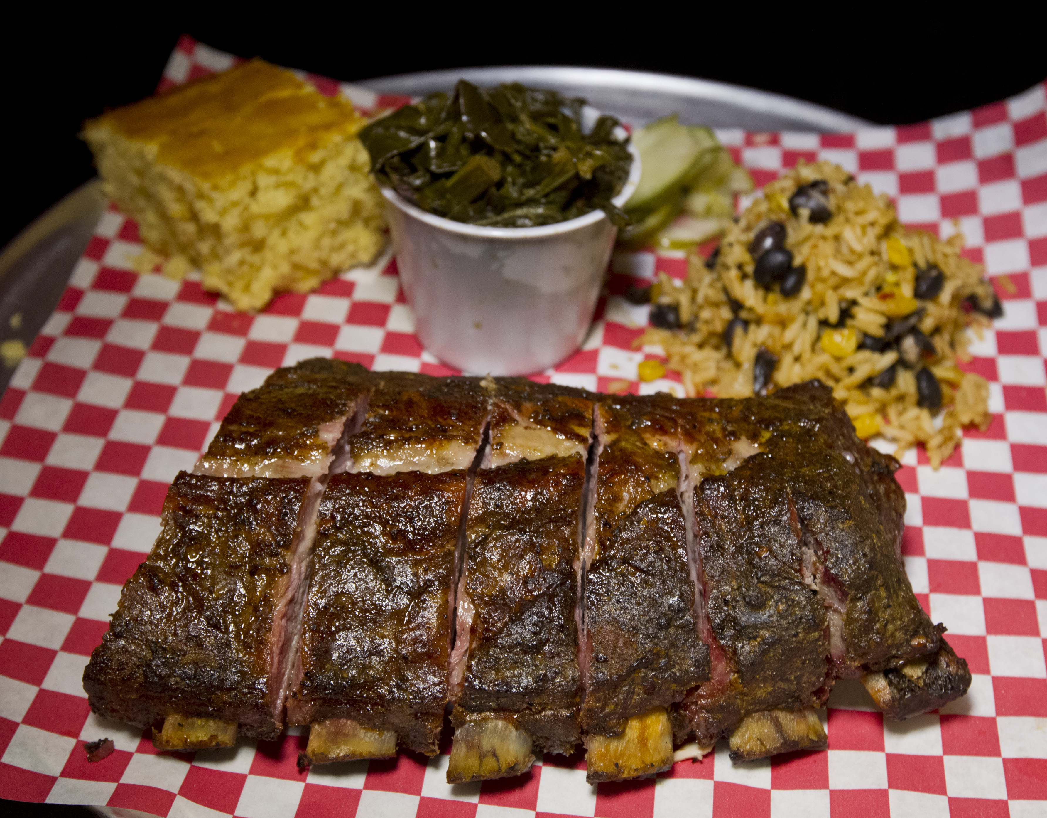 Half rack of baby back ribs, collard greens, rice and beans, and corn bread.