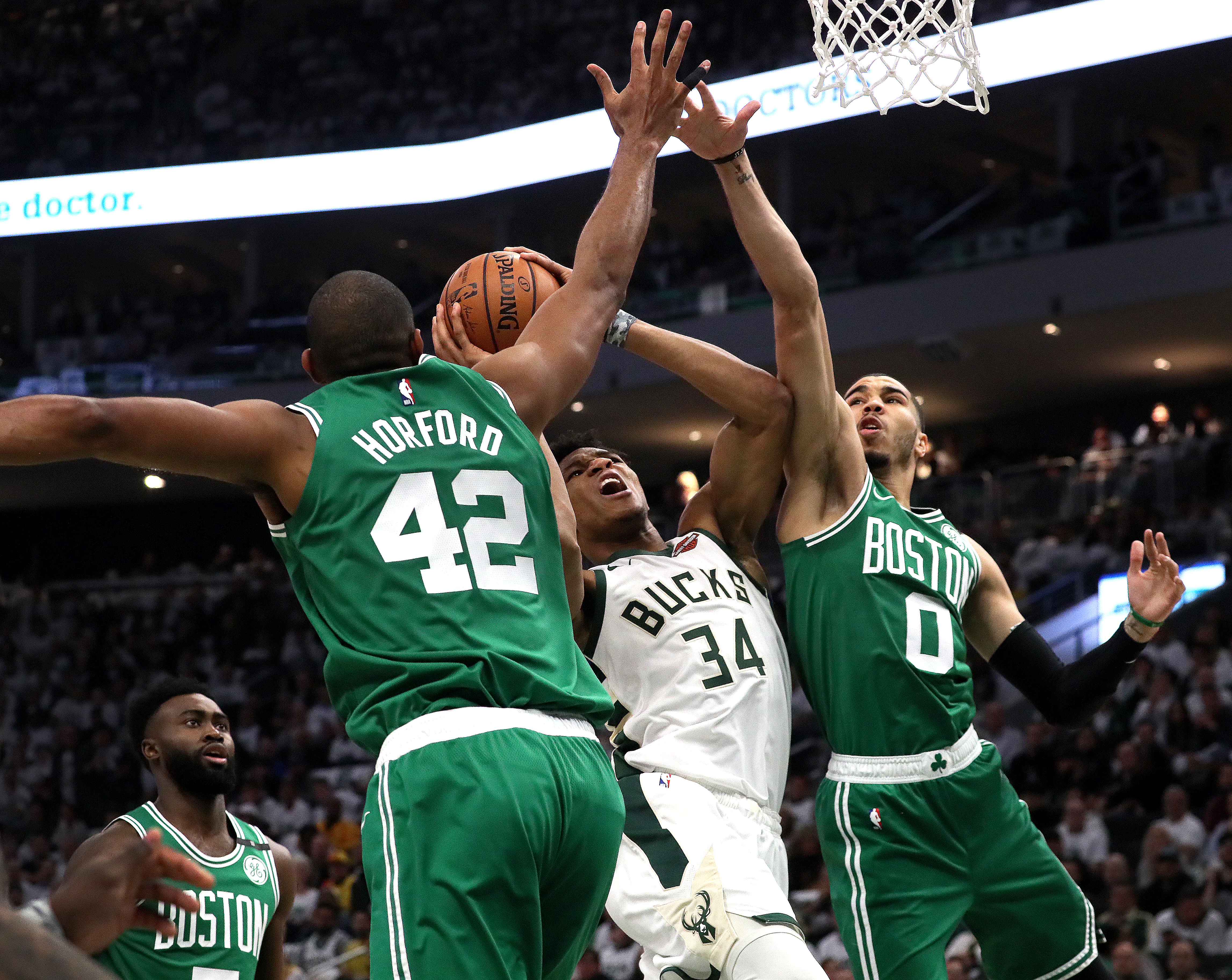 Giannis Antetokounmpo felt the pressure early in Game 2 — here from Al Horford and Jayson Tatum — before breaking out.