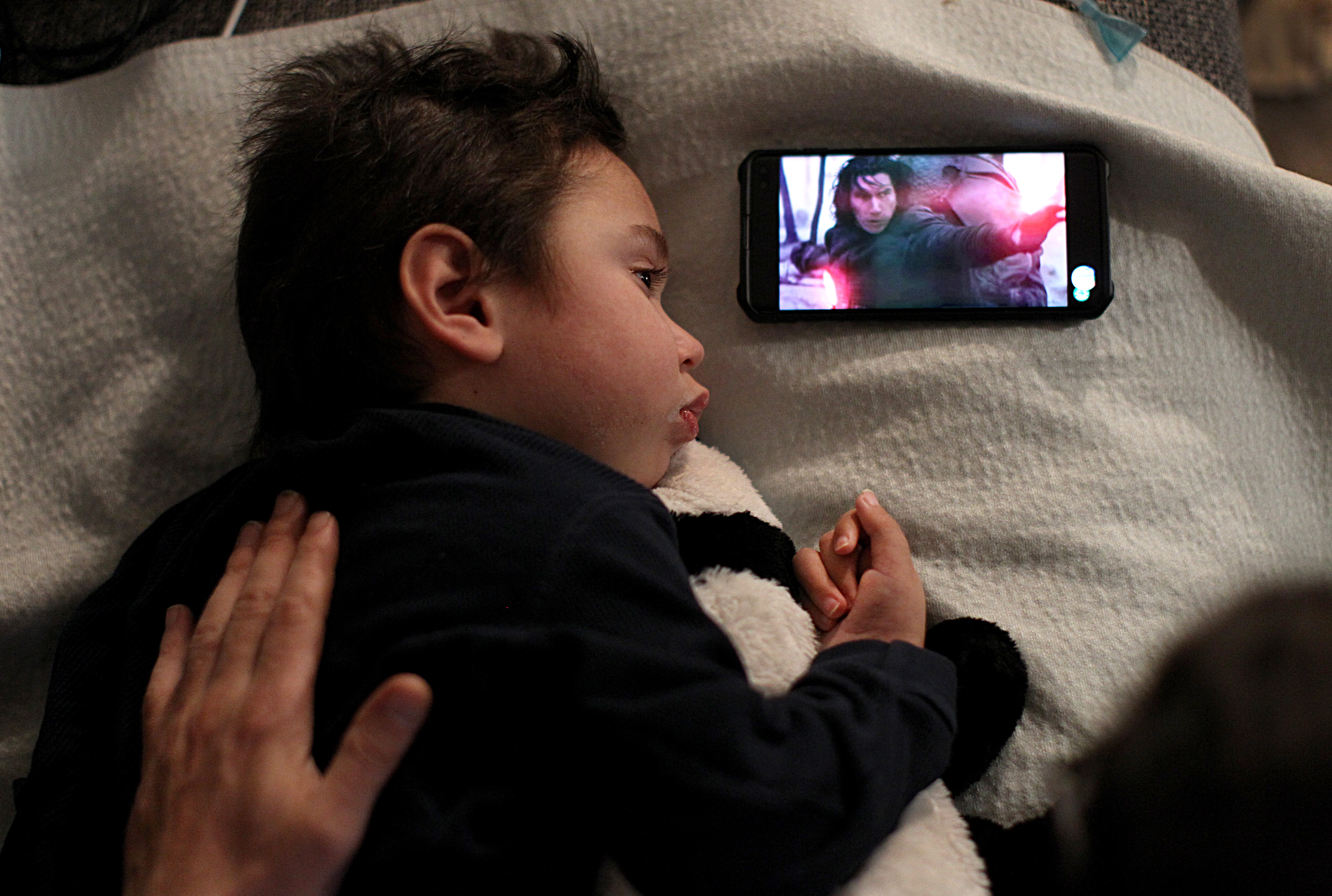 Before his debilitating sickness, Lucas loved to watch Star Wars movies with his father, Nathan, who still props up a phone for Lucas to watch.