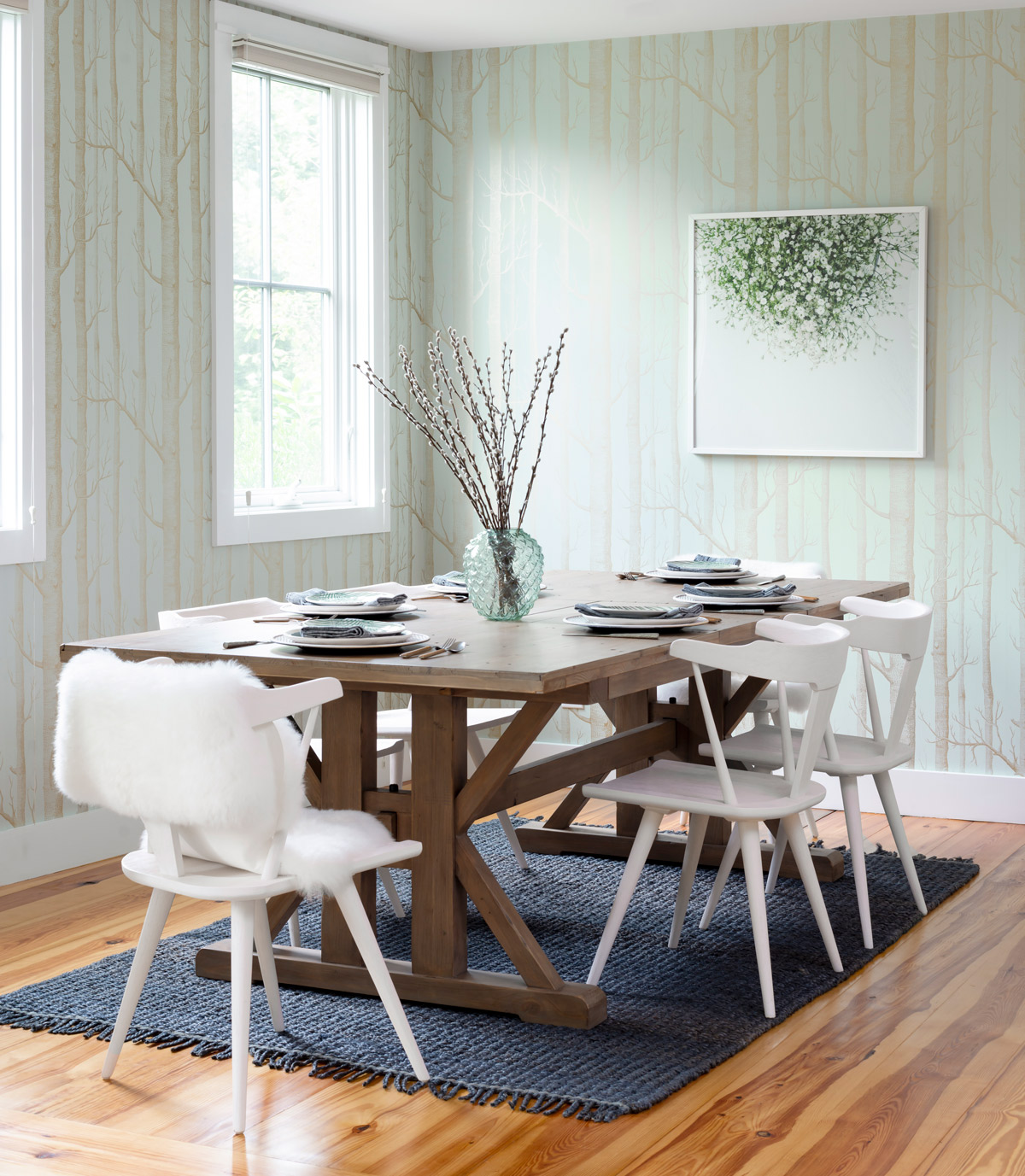 The natural feel of the La Pergola extension table by McGee & Co. balances the glam gold accents of the wallpaper in the dining area. The print, Gypsophila, by Marabou Design, came from Minted.