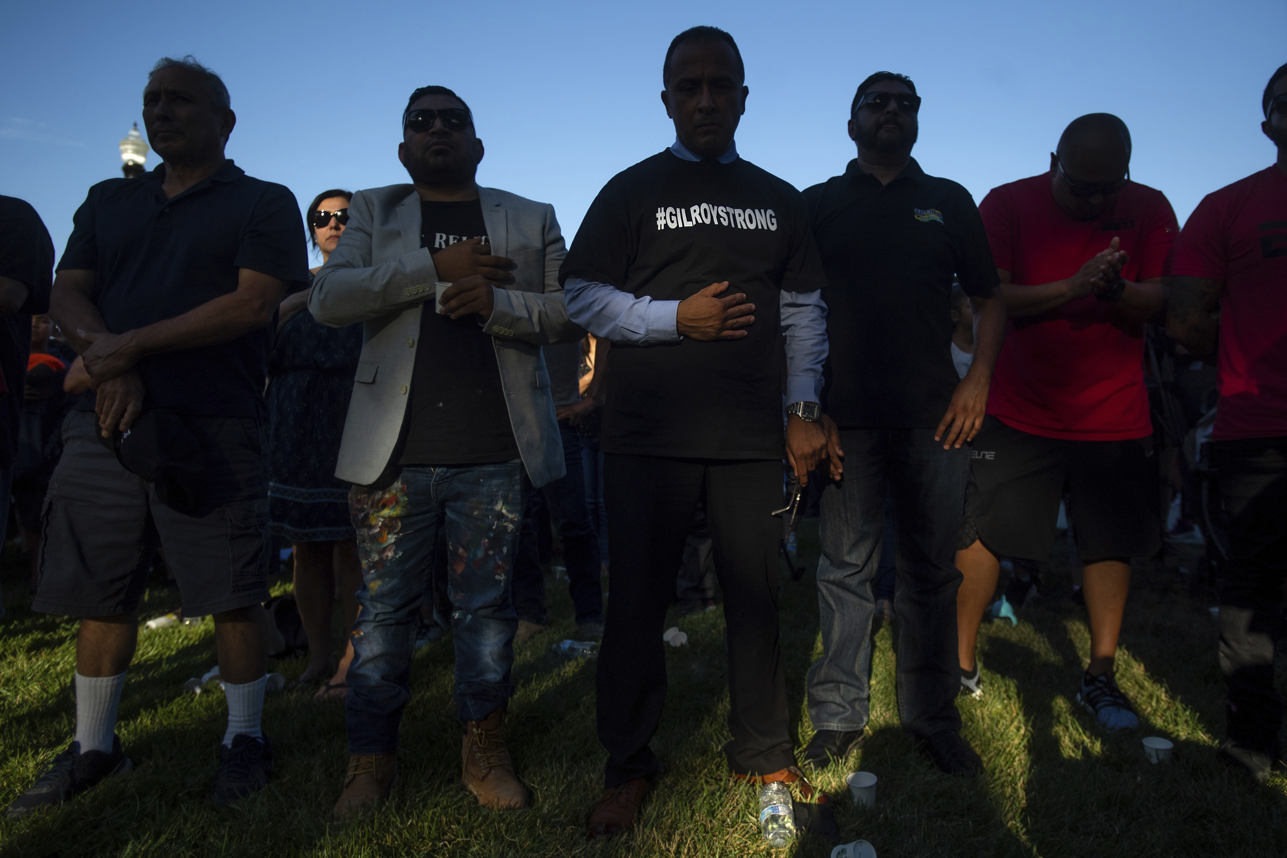 Gilroy City Council member Fred Tovar (center) wore a #GILROYSTRONG shirt while attending a vigil for victims of a deadly shooting at the Gilroy Garlic Festival last week in Gilroy, Calif.