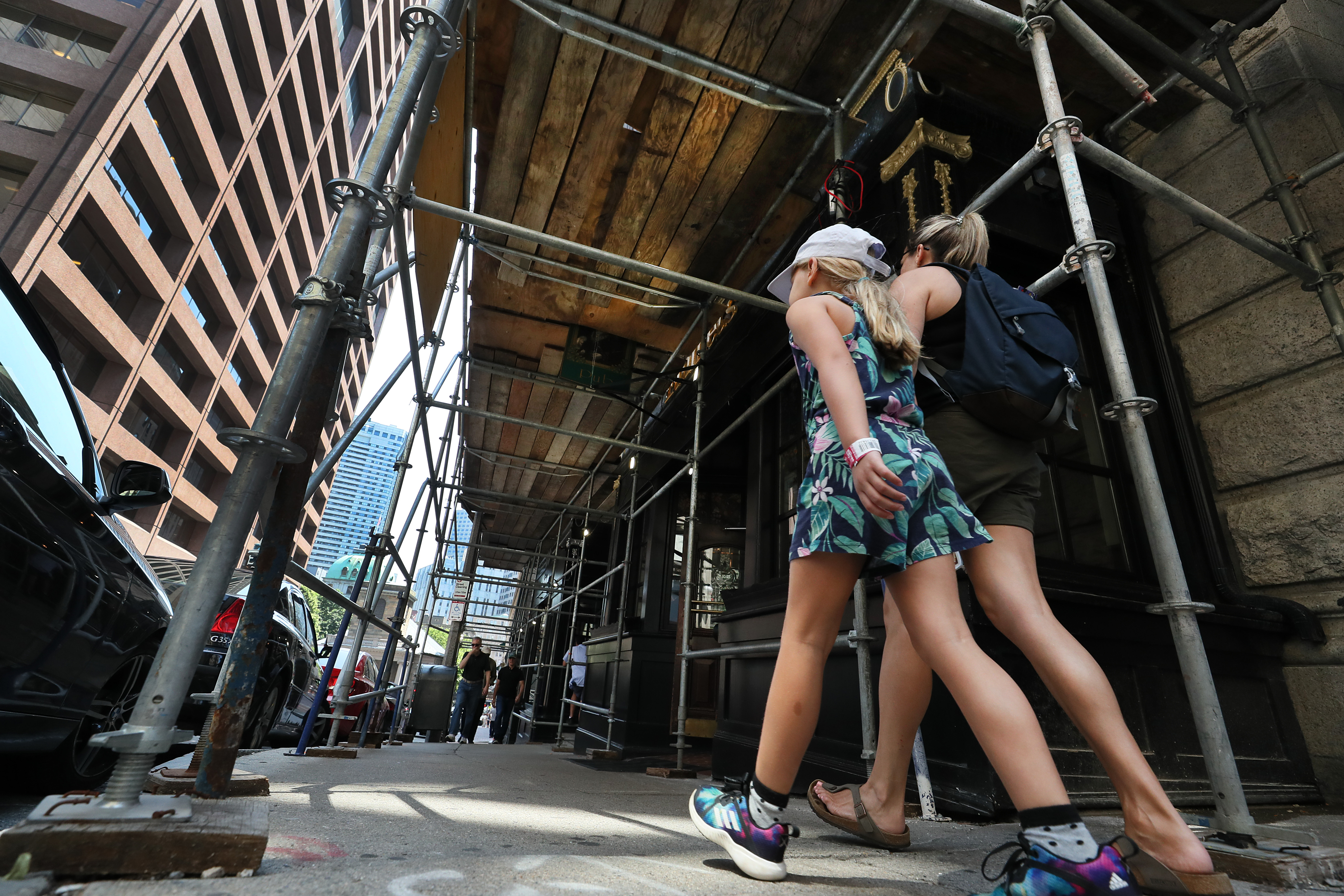 Pedestrians walked under a scaffold in front of a Beacon Street building under construction.
