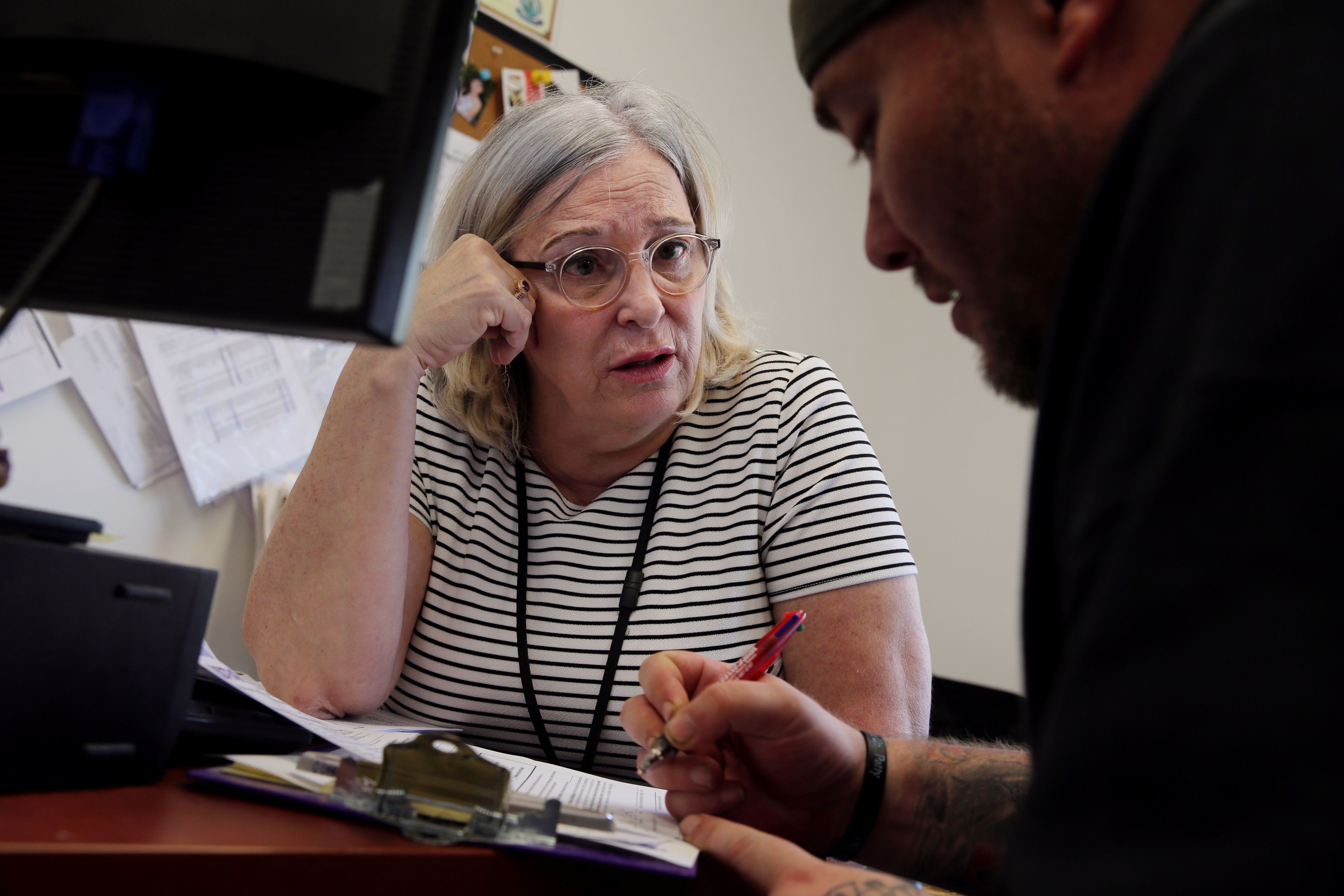 OTC Clinician Kathy Belanger (left) talked with a client about his needs after she secured a bed for him.