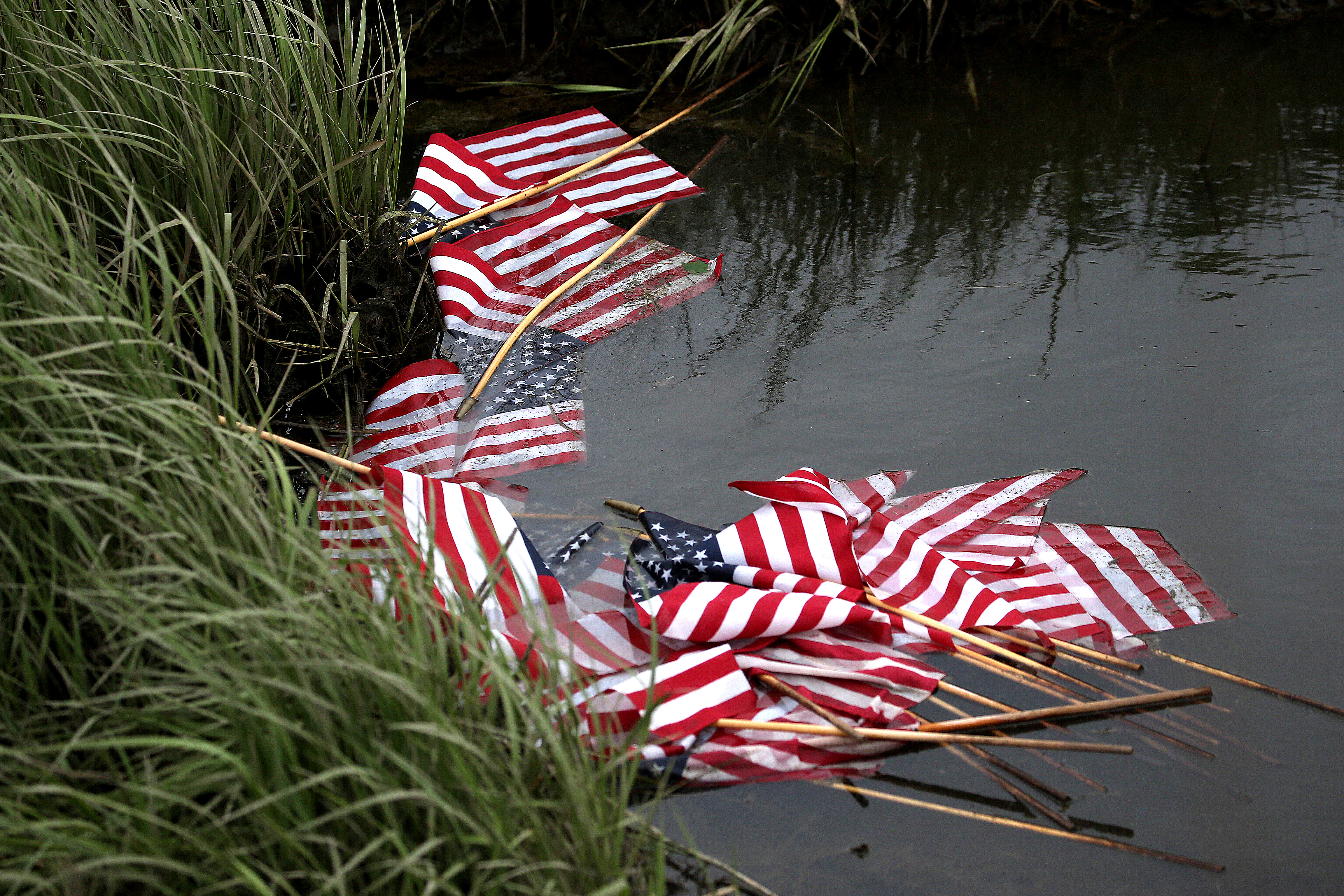 Flags that had been placed at the memorial were thrown into the water nearby.