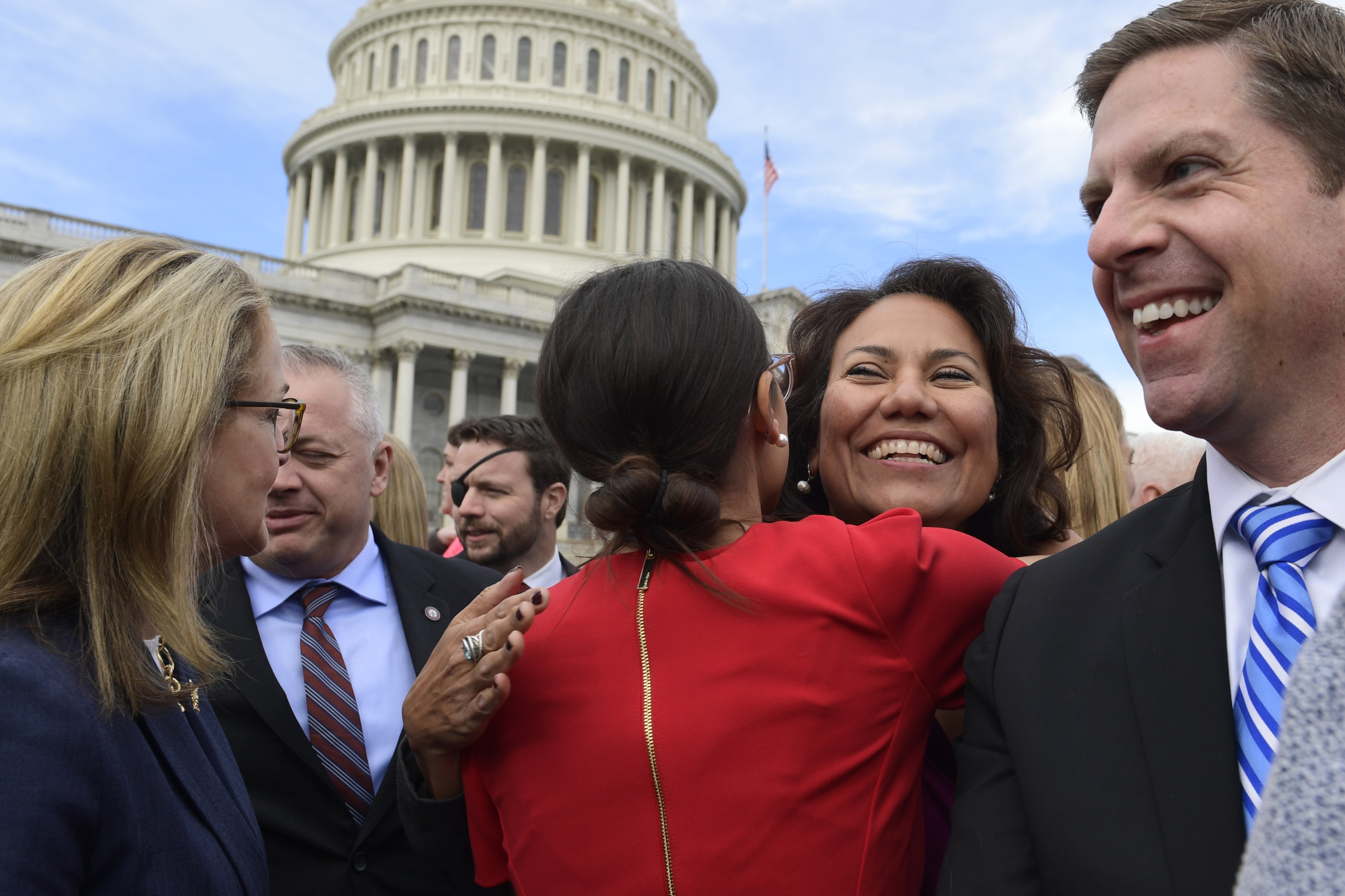 Representative-elect Alexandria Ocasio-Cortez, D-N.Y., center in red, got a hug from Representative-elect Veronica Escobar, D-Texas, on Capitol Hill on Wednesday, with the freshman class.