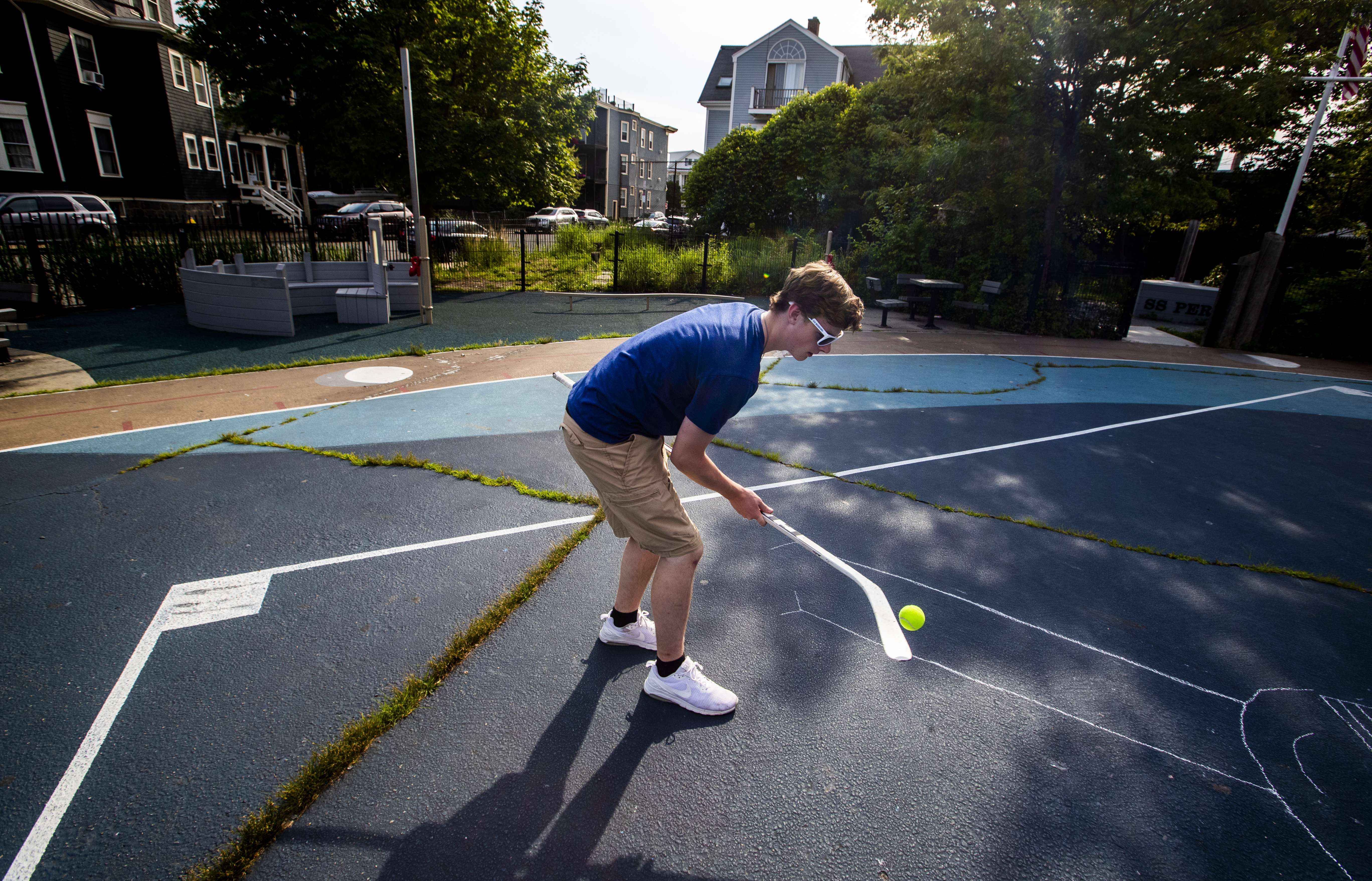 Lydon McGarrell of South Boston practices street hockey by himself, the teen choosing sports other than baseball to play with his neighborhood friends.