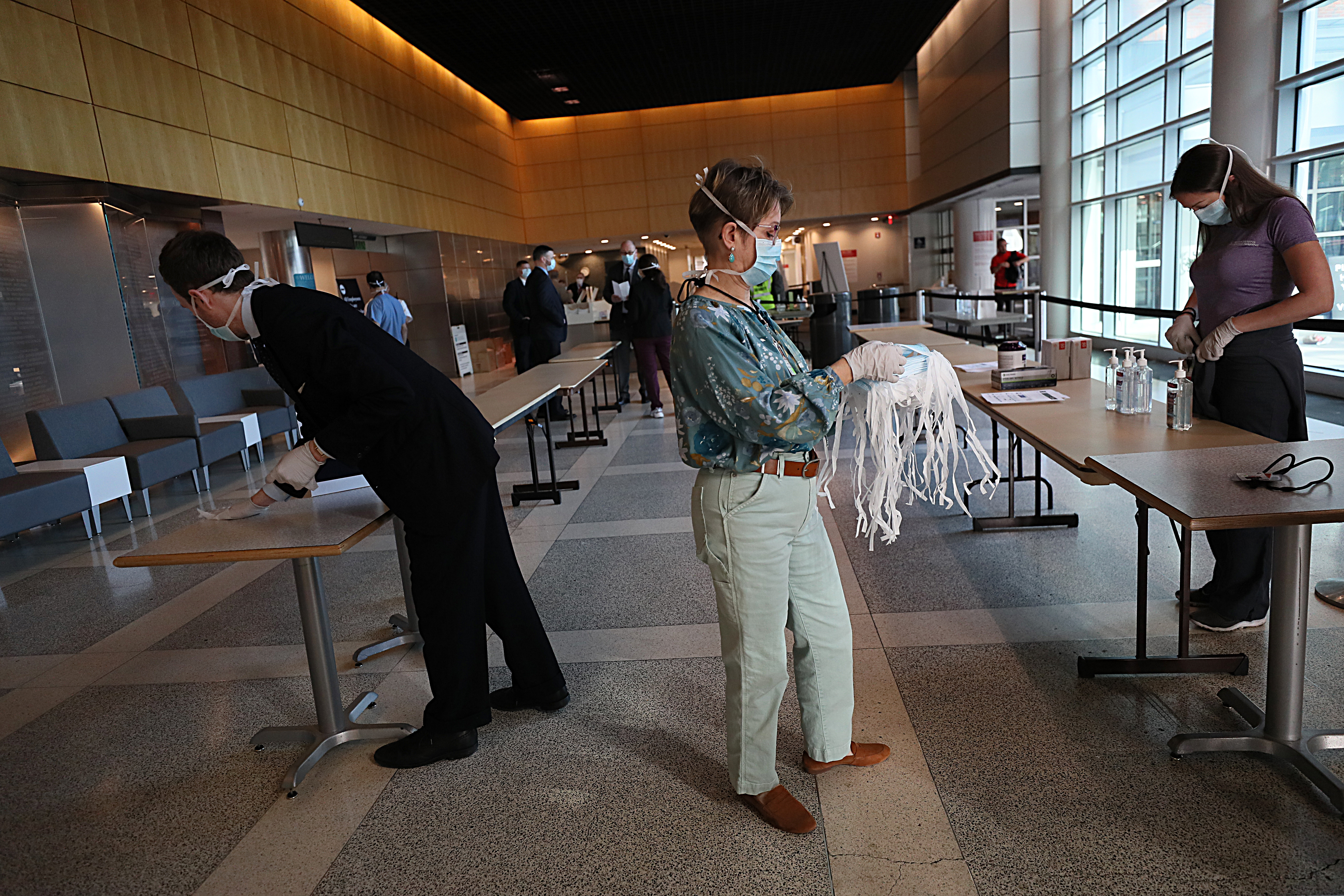 Mary Beth Mesrobian, a dental hygienist at Massachusetts General Hospital, has been deployed to hand out masks and hand sanitizer to all who enter the lobby.
